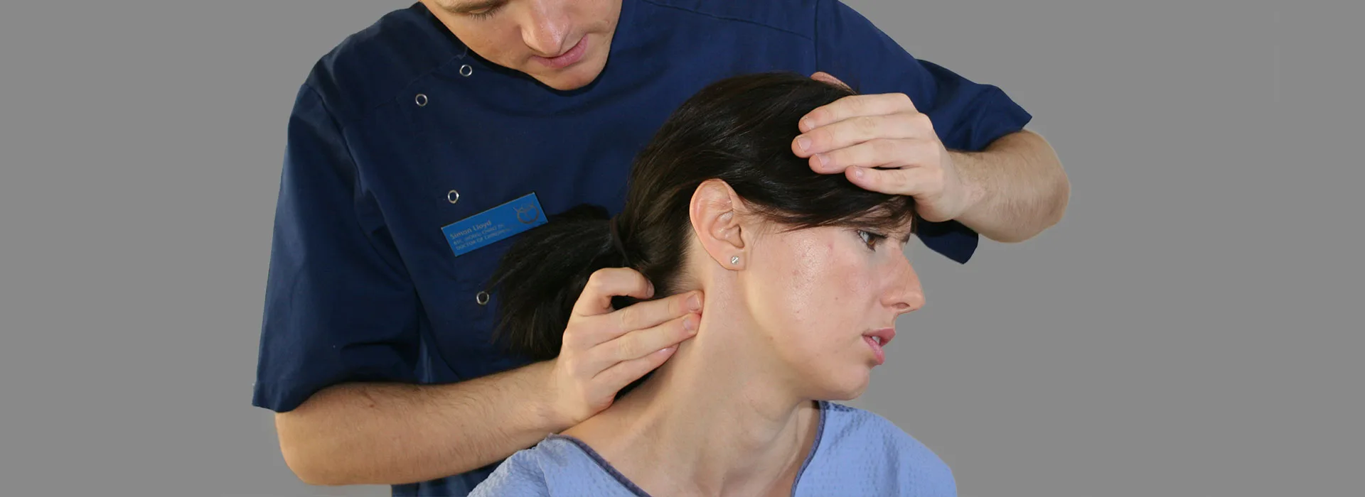 Chiropractor at Hertford Chiropractic gently supporting a patient’s head and neck during treatment