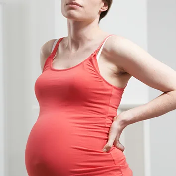 Pregnant woman holding her lower back
